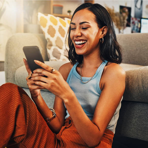 Woman smiling and checking credit score on her phone