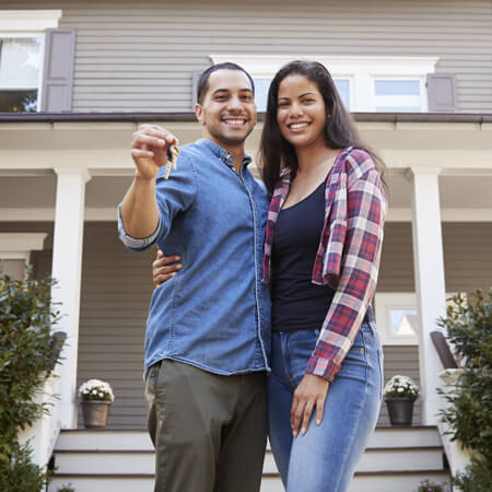 Una pareja feliz con las llaves de su casa