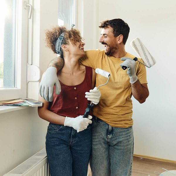 happy couple looking at each other with painting supplies