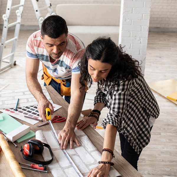 pareja feliz mirándose con artículos para pintar