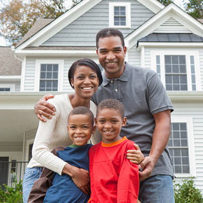 Happy family in front of their home.