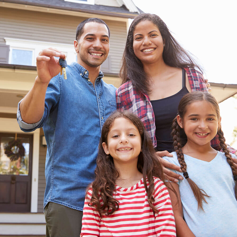 Family outside house with set of keys